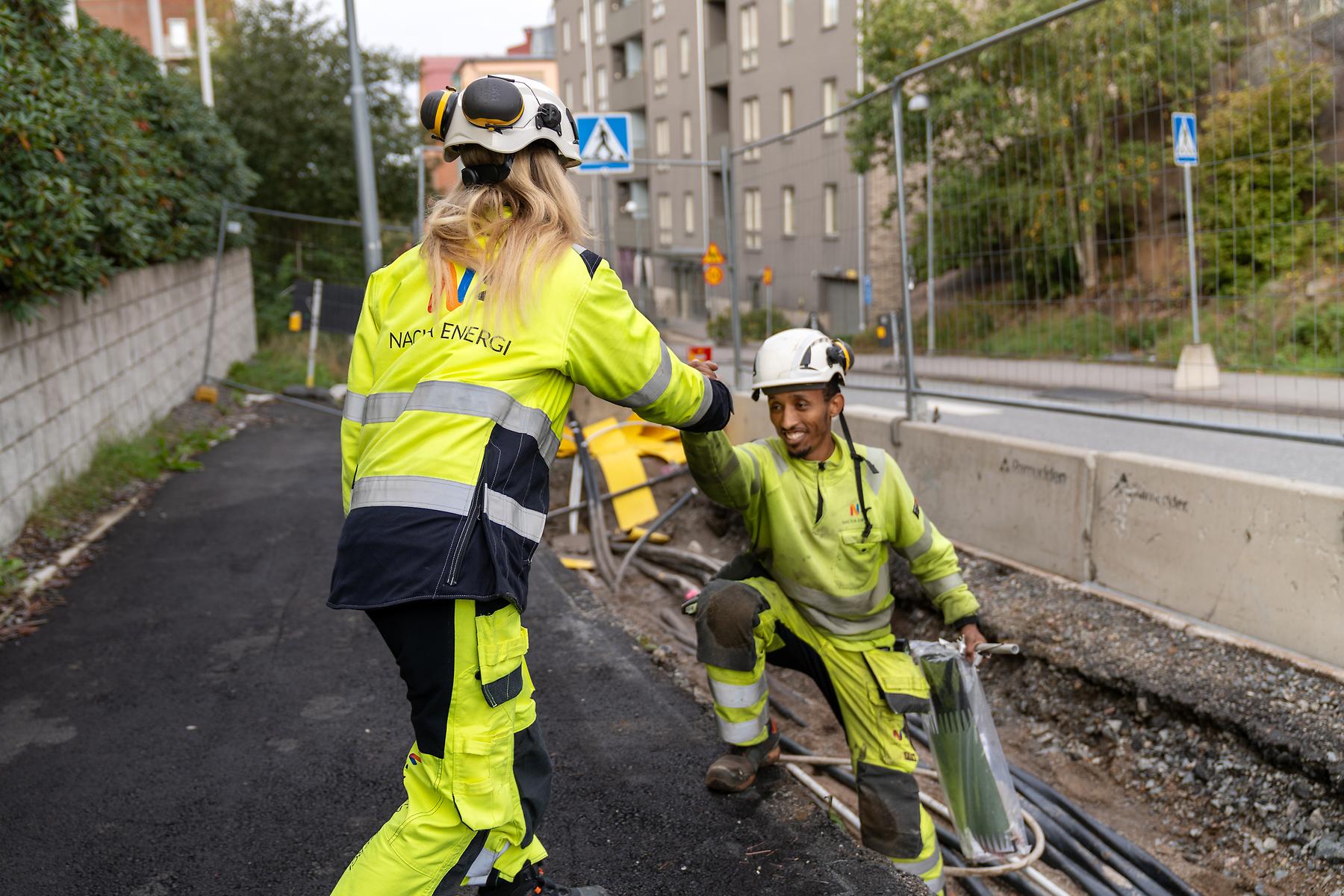 Montörer som arbetar i grop